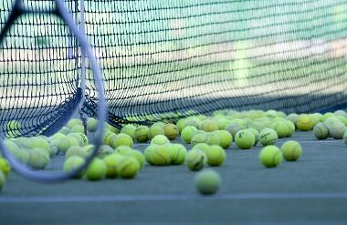 Tennis racket and balls on court