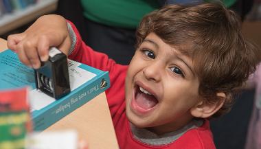 Little boy holding a book date stamp