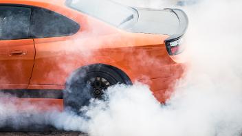A sports car does a wheelspin creating tyre smoke