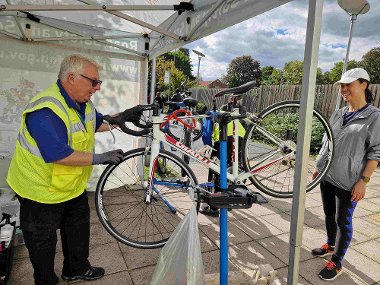 Man in high vis fixes woman's bike