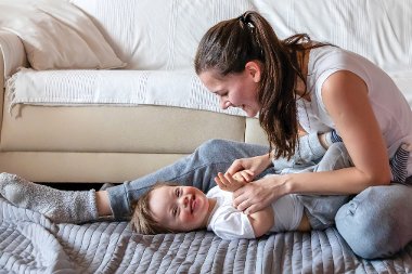 Cute small boy with Down syndrome playing with mother in home living room images