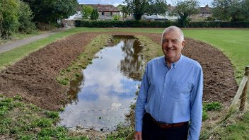 Cllr Eddie Lavery stands next to the flood alleviation 'swale' in Bessingby Park, Ruislip