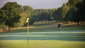 General view of Uxbridge Golf Course with a green in the foreground and a player approaching down the fairway